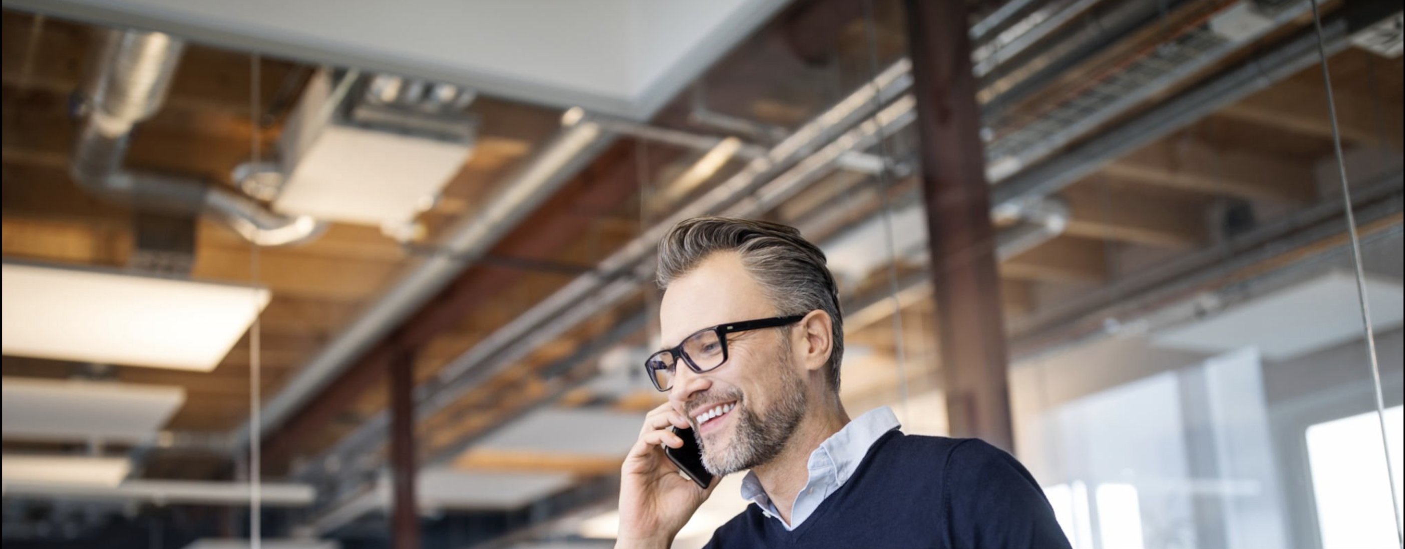 Business professional speaking on a phone in an office